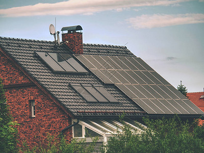 房顶上有太阳能电池板的家屋与云图片