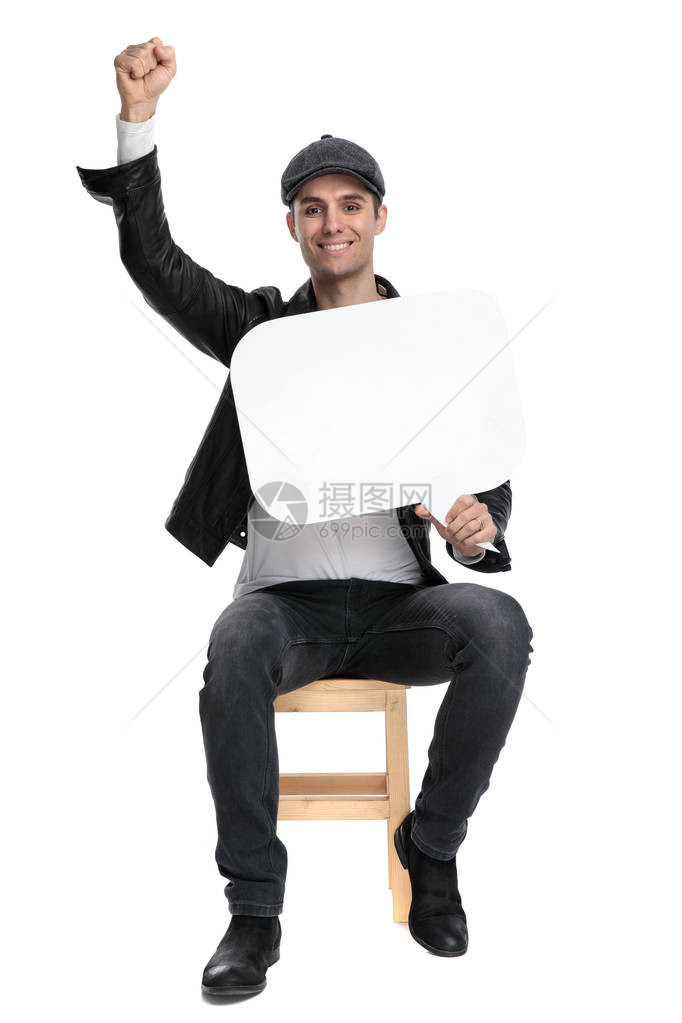 穿着黑色皮夹克和帽子的休闲男士坐在白色工作室背景下图片