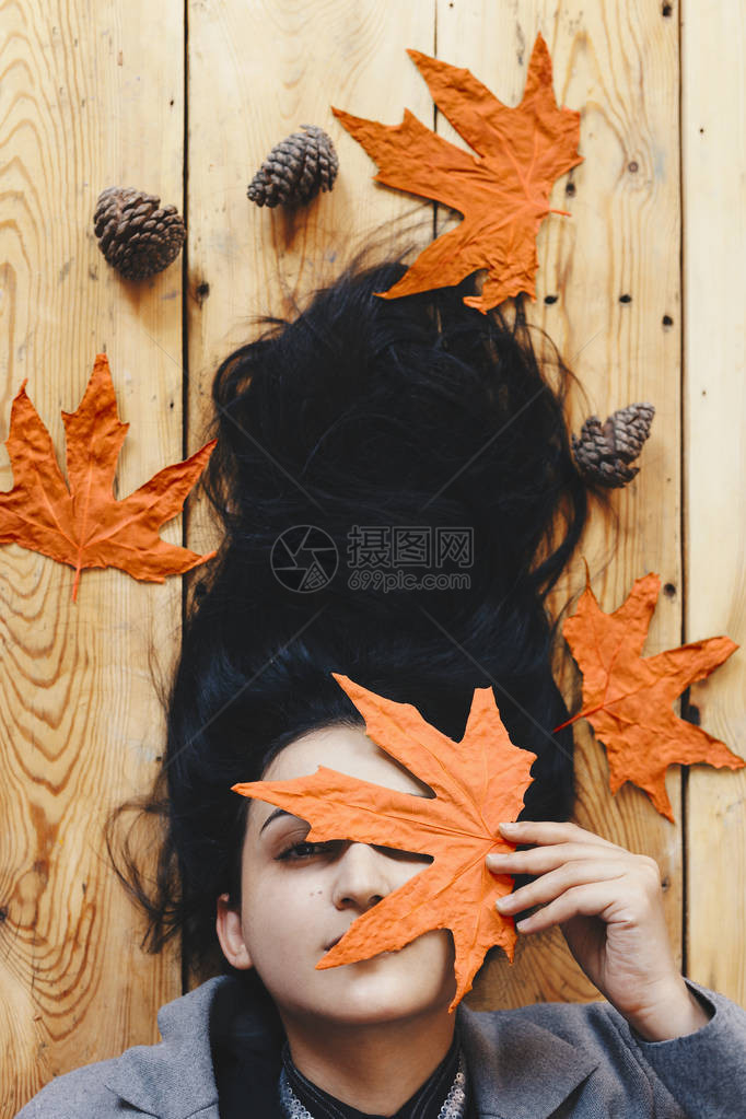 秋天的女人秋季的概念躺在木地板上的女人的肖像年轻美丽快乐的女拿着大黄秋叶漂亮的女孩图片
