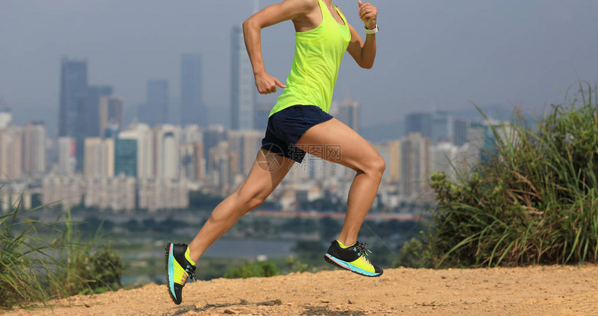 女特马拉松跑步者在现代城市旁图片