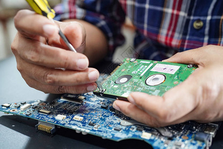 技术人员通过烙铁修复硬盘内部集成电路数据硬件技术人员图片