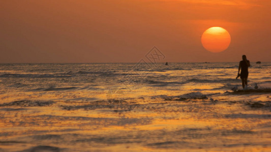 夕阳红的天空下波涛汹涌的大海图片