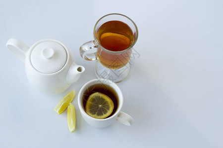 白色杯子和玻璃杯中含柠檬的茶叶图片