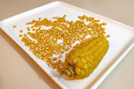 把煮熟的玉米和玉米粒放在盘子里图片