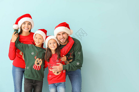 圣诞节穿圣诞毛衣的幸福家庭和穿着颜色背图片