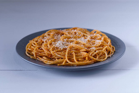 面条加番茄酱和干酪白木桌上的意大利面条图片