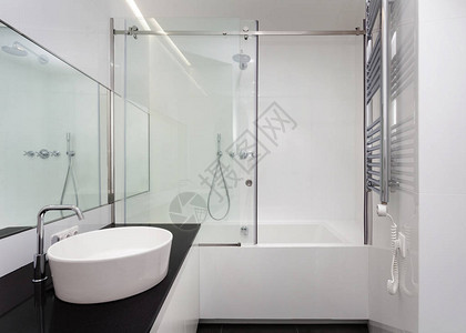 白色浴室配有浴缸面盆淋浴大镜子和镀铬银加热器或墙上的电毛巾散热器有当代内背景图片
