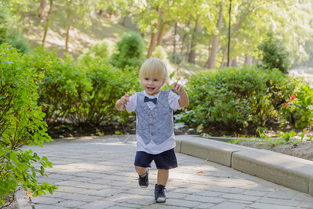 小男孩在公园的柏油路上奔跑图片