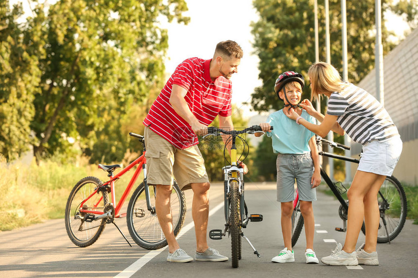 父母教儿子在户外骑自行车图片