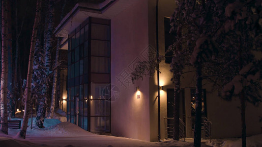 冬季深夜大房子的面孔被一辆紧急车多彩闪耀的闪光照亮外面看到晚上寒冬雪中小背景图片