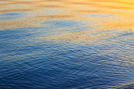 蓝色和橙色的清水纹理海洋和海的背景被太阳图片