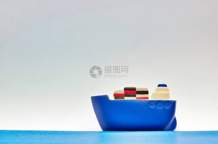 载有多彩航运集装箱的玩具蓝货船图片