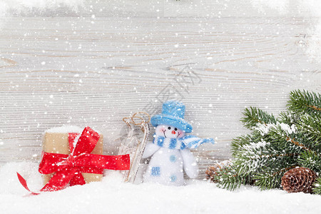 圣诞雪人玩具礼品盒和fir树枝图片