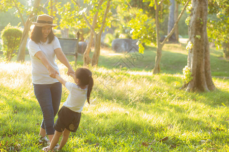 年轻的亚洲母亲和小女儿在公园里玩得开心快乐图片