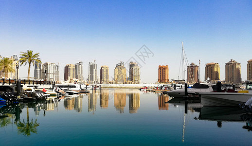 卡塔尔珍珠豪华住宅楼全景和阿拉伯港码头的白色游艇图片