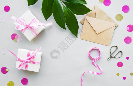 礼品盒信封和白色背景上的绿叶图片