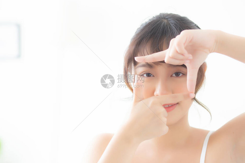 美丽的年轻亚洲女眼部皮肤护理和手势框架用手于视觉图片