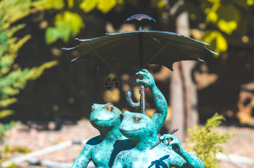 雨伞下相爱的青蛙雕塑图片