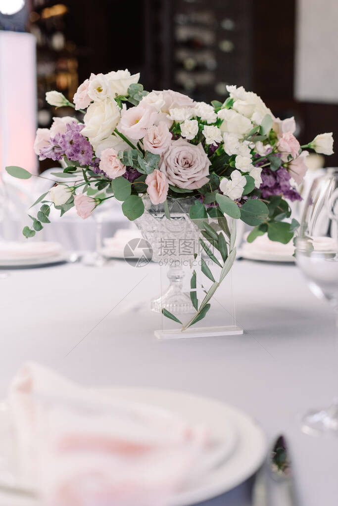 水晶花瓶中的美丽花朵为餐厅的新郎和新娘的客人装饰了一张的餐桌来自活花的奢华图片