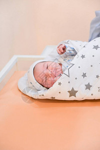 婴儿裹在毯子里刚出生的婴儿在亚克力医院摇篮里用婴儿毯包裹着睡的图片