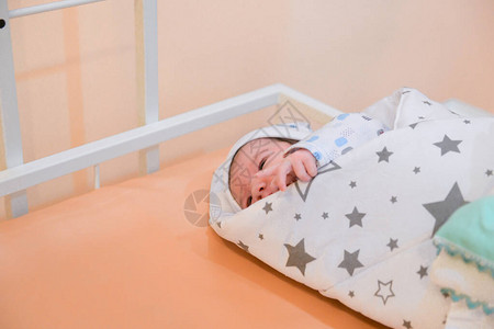 婴儿裹在毯子里刚出生的婴儿在亚克力医院摇篮里用婴儿毯包裹着睡的图片