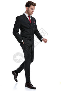 穿着双排扣西装和红色领带的优雅年轻商人的侧视图图片