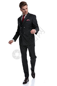 身穿双排扣西装和红色领带的时尚现代商人图片