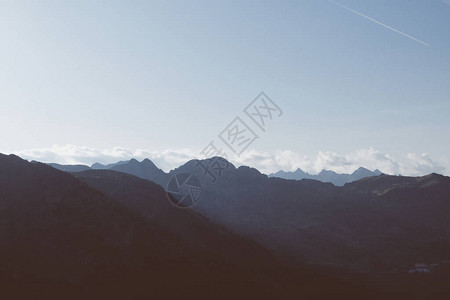 美丽的高山景观与日落期间的山脉轮廓阿尔卑斯山的图片