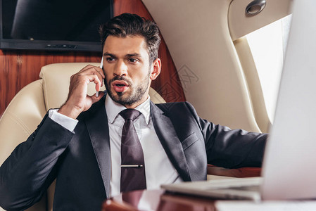 穿西装在私人飞机上用智能电话聊图片