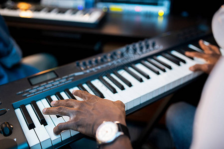 年轻的非洲作曲家或音乐家在录音室工作时用手触摸图片