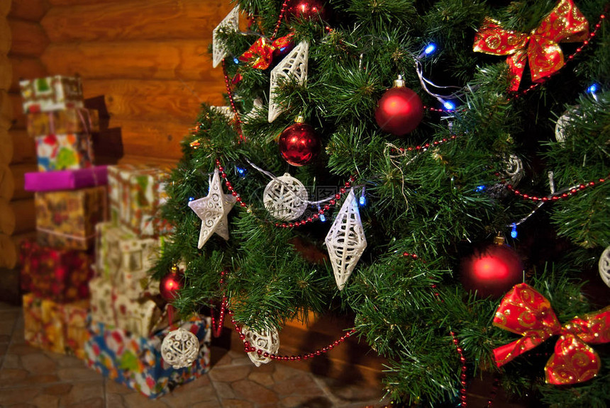圣诞树装饰着花环和木制背景上的层闪亮和玩具关闭圣诞树上的多色装饰背景中图片