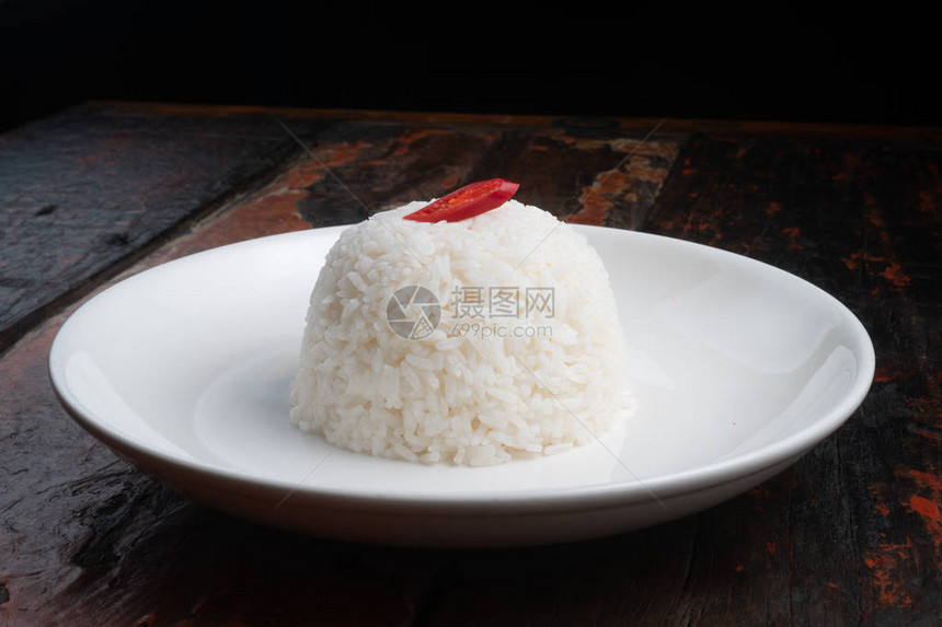 白色盘子上的茉莉花蒸米饭在生锈的木制厨图片