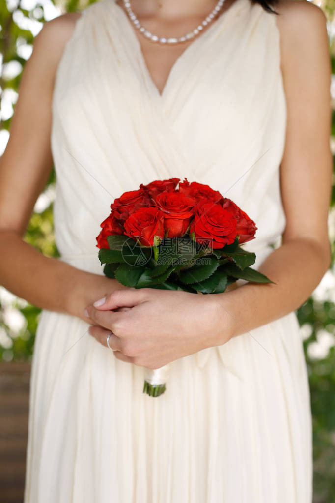 新娘手捧红玫瑰花束特写图片