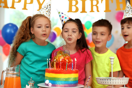 孩子们在蛋糕附近在室内的生日派对上图片