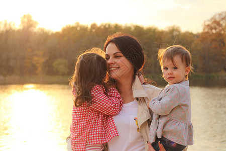 在秋湖岸边怀着两个孩子的幸福母图片