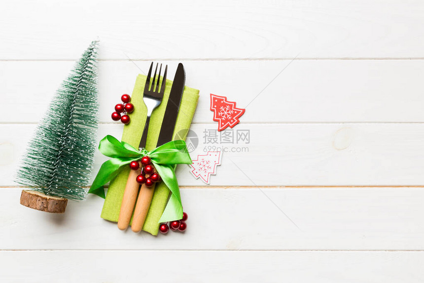 用丝带绑在木制背景的餐巾纸上的叉子和刀子的顶部视图圣诞装饰品和新年树快乐的假期概念图片