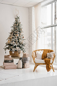 在客厅的圣诞树上彩色明亮地板到天花板窗户旁的图片
