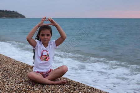 7岁的小淘气女孩长头发的7岁长发在海背景图片