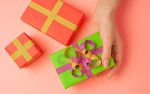 家里用彩色纸和丝带手工女手亲制作的节日礼物图片