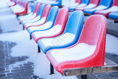 冬季体育场内被雪覆盖的多色座椅降雪干扰运动未清洁的体育场图片