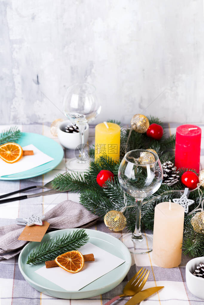 节日圣诞节和新年餐桌设置与干橙色和肉桂灰色纺织品用松果树枝和蜡图片