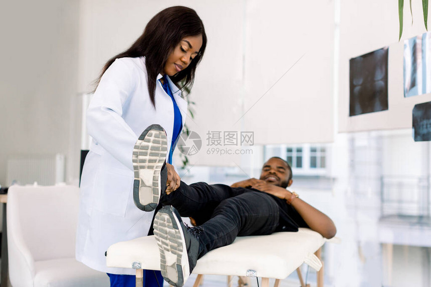 医生和病人在医院检查腿非洲女医生在现代诊所检查男Arica图片