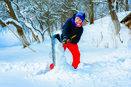 村里有个小男孩清理雪散步图片