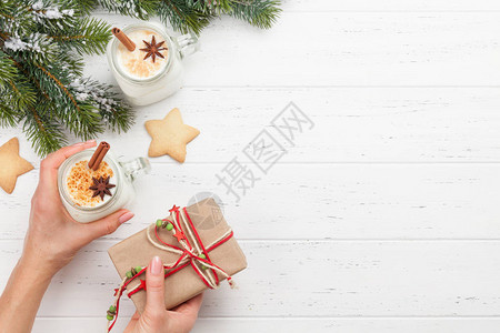 Eggnog传统圣诞节鸡尾酒和姜饼干木制桌上有xmas礼品盒图片