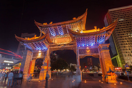 云南民族村大门和许多人正在云南省昆明市观光访问背景图片