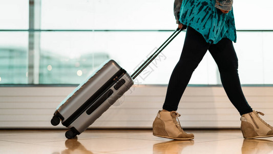 带手提箱的旅行者带着行李和乘客在机场航站楼图片