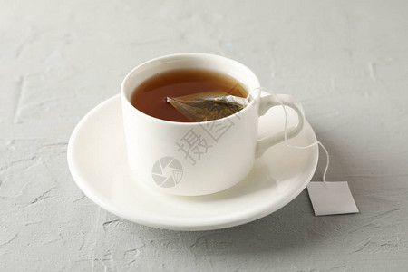 一杯茶灰色背景的茶包特写图片
