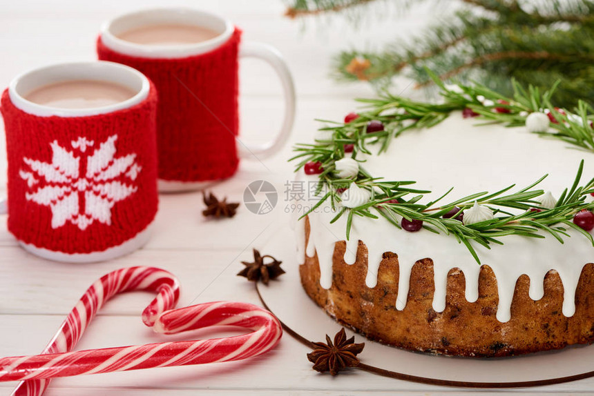 糖果甘蔗有糖霜的圣诞节派和白木桌图片