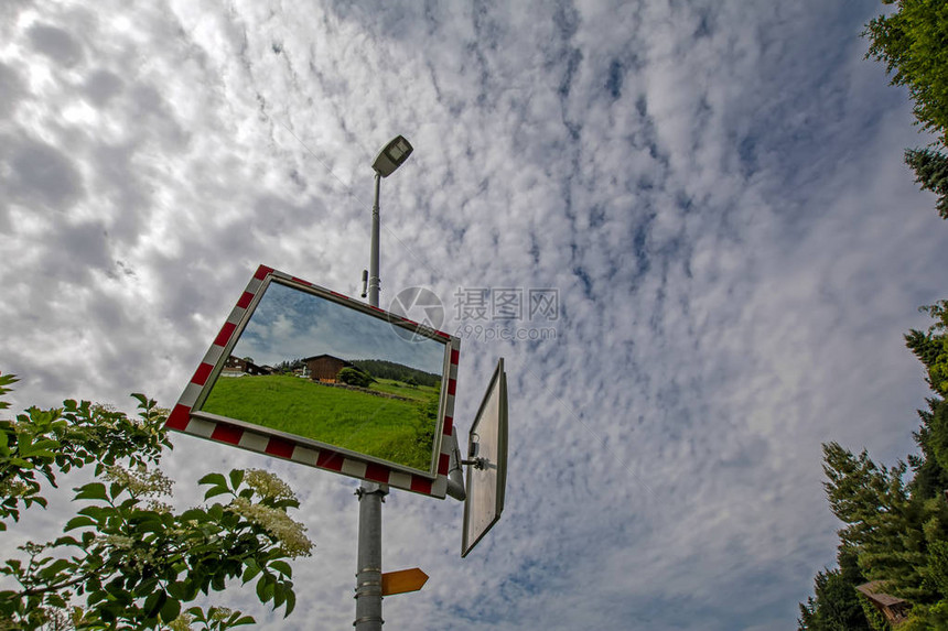 街道上安全道路交通镜的低视角与多云的天空映衬着木制传统小屋瑞图片