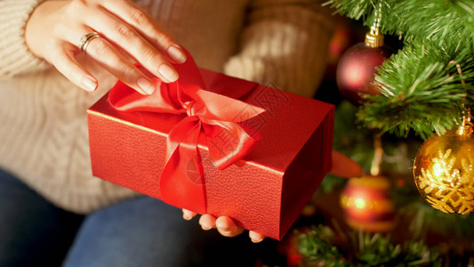 女举手拉红丝带和打开圣安塔圣诞礼物图片